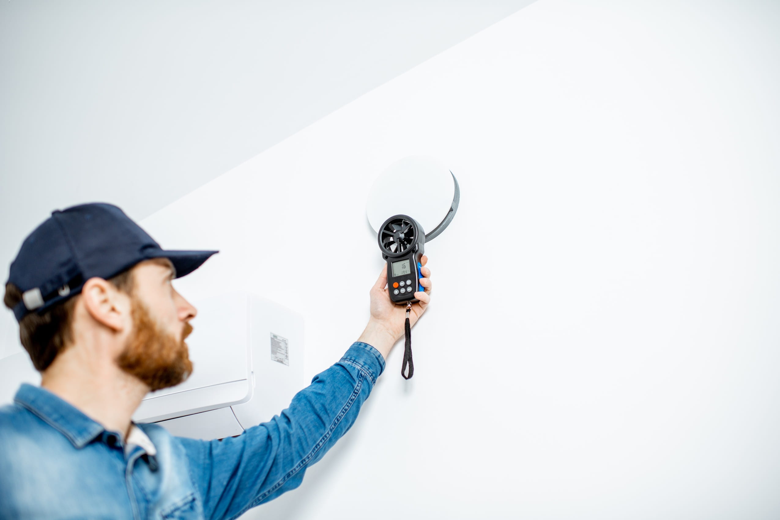 man-inspecting-air-conditioning-equipment-in-brigh