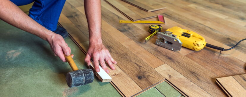 man-installing-wood-flooring-with-tools
