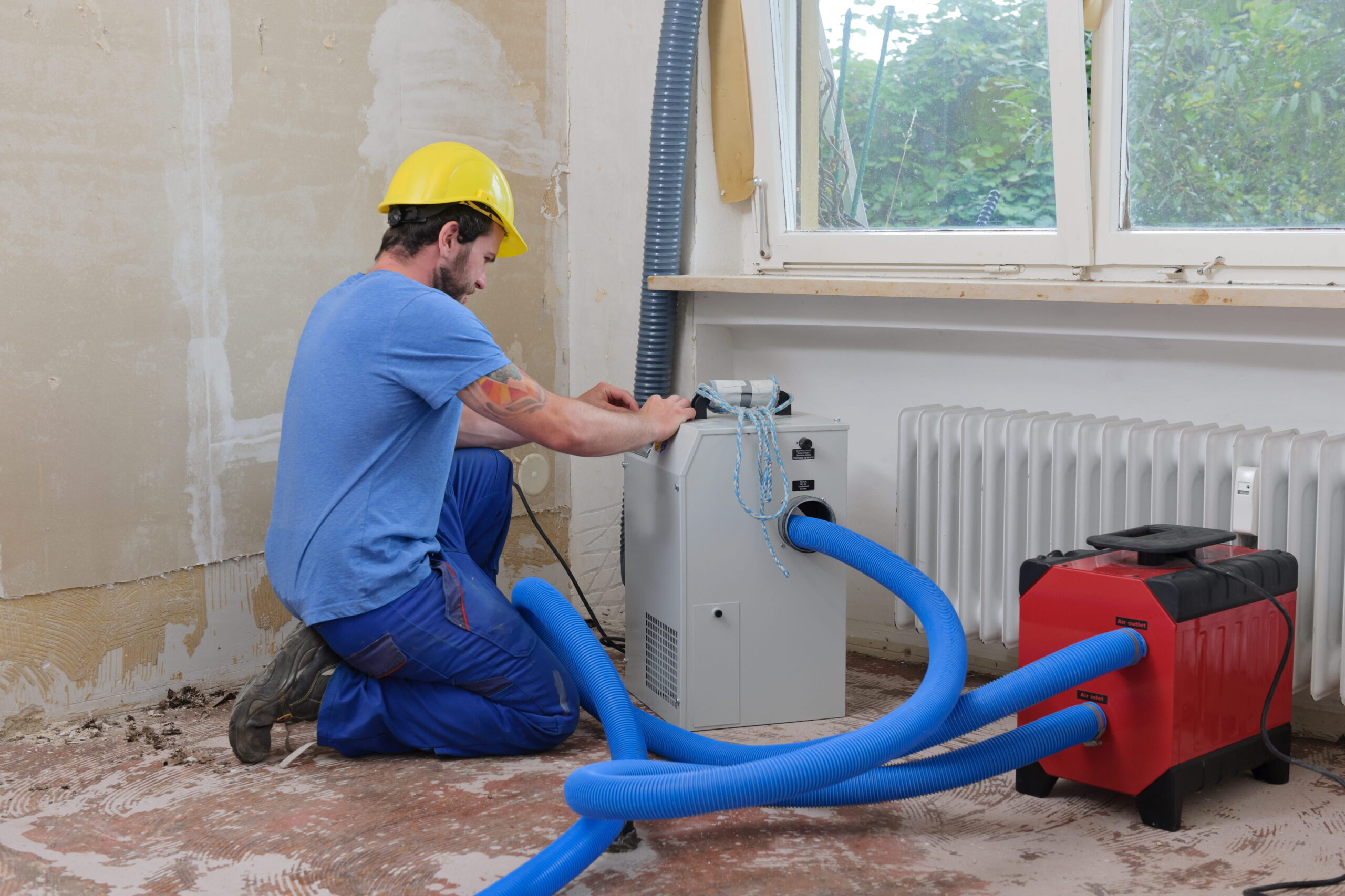 man-working-with-restoration-equipment-in-room
