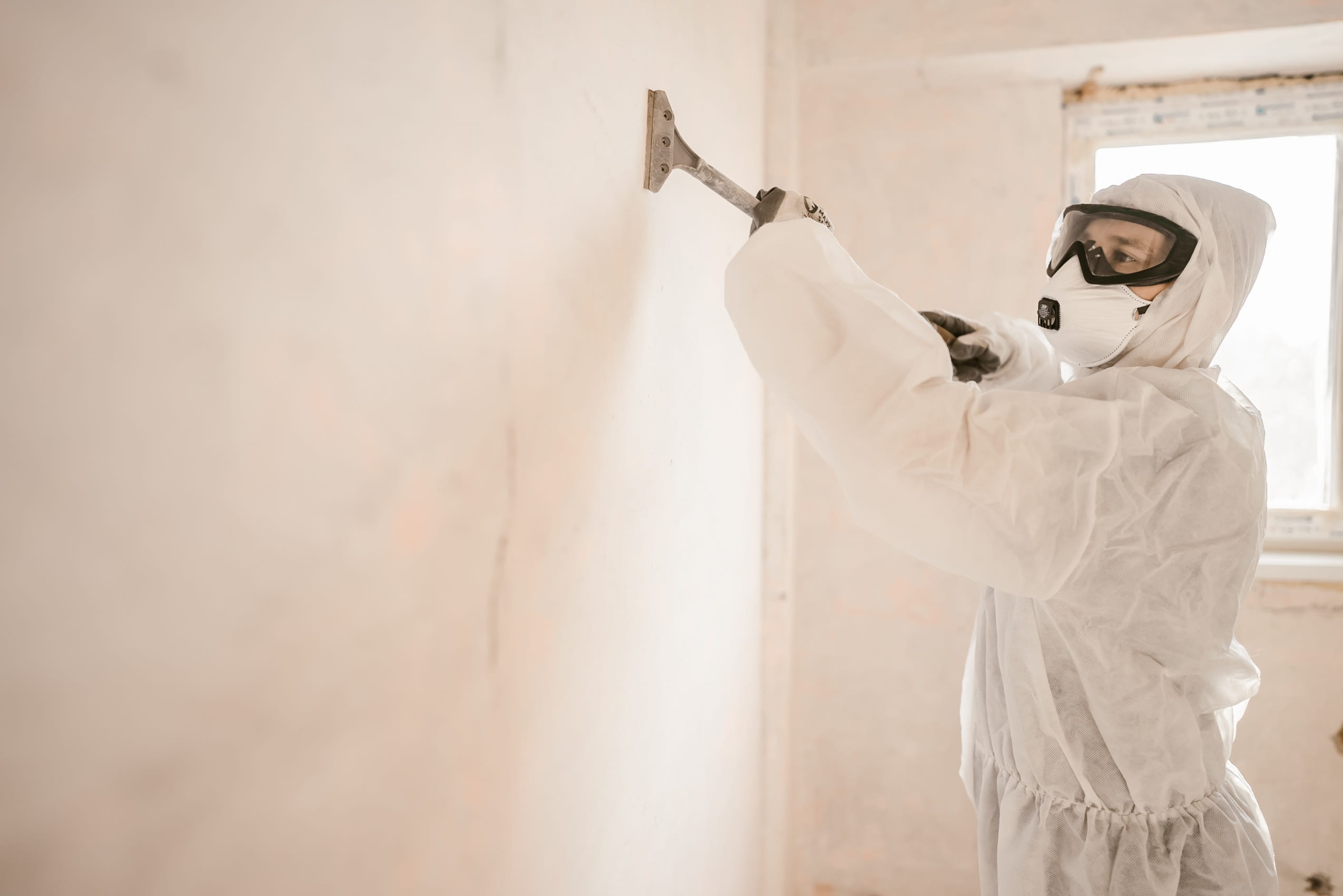 worker-prepares-wall-for-painting-in-protective